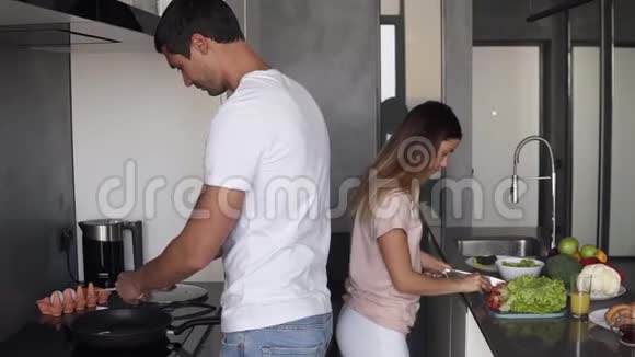 休闲夫妇一起在家庭厨房做早餐积极的漂亮女人切沙拉英俊的视频的预览图