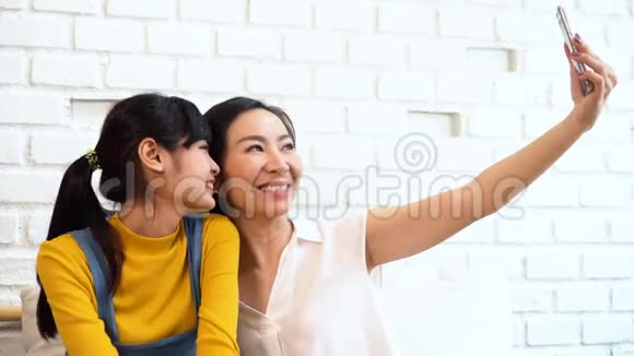 快乐的亚洲少女和中年母亲自拍或视频电话视频的预览图