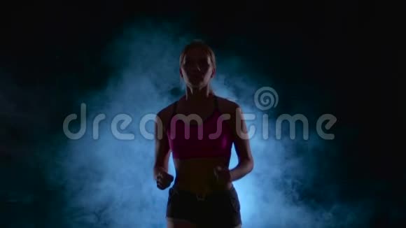 女生健身稳步进行前景烟雾中的黑色屏幕剪影慢动作关门视频的预览图
