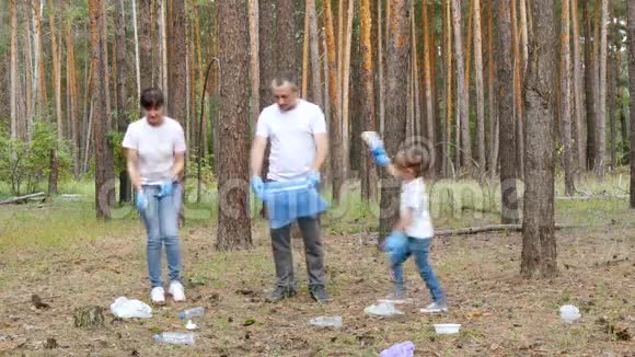 活动家庭爸爸妈妈和他们的儿子通过把杂物放在袋子里清洁公园里的杂物儿童教育视频的预览图