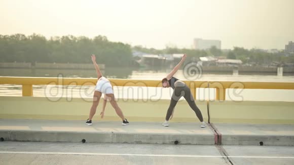 运动员女人在海滩路跑之前热身亚洲女跑运动员夏季耐力训练视频的预览图