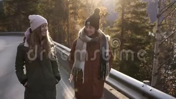 穿着冬装的积极的女游客在一条漫长的道路上缓慢地走着穿过农村走向下雪视频的预览图