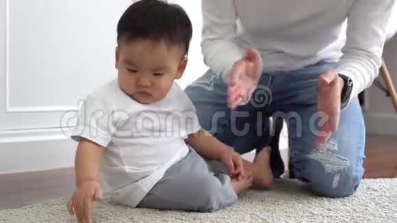 快乐的亚洲家庭年轻的父亲在家里和小男孩一起玩游戏和拍手视频的预览图