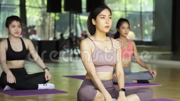 一群亚洲女孩在健身房健身班做瑜伽伸展姿势快乐的年轻人视频的预览图