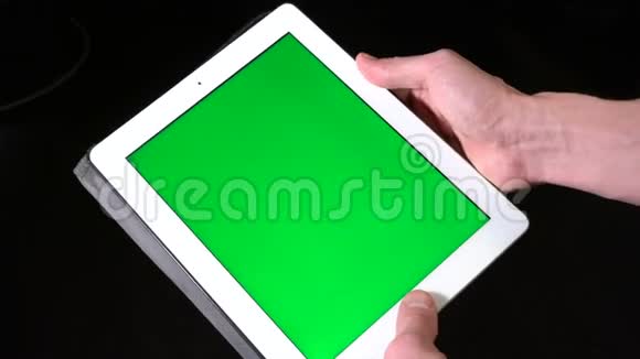 双手使用带有绿色屏幕的平板电脑视频的预览图