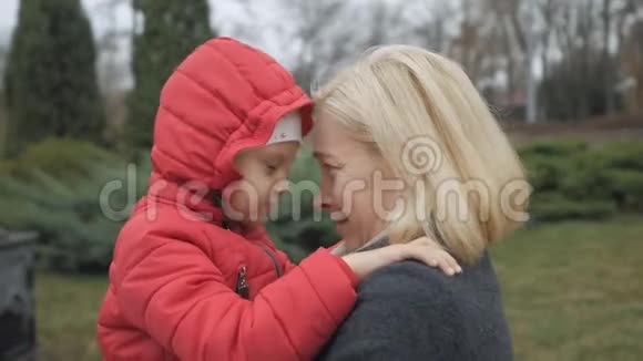 成熟的女人和小女孩抱着她在秋天公园玩微笑玩视频的预览图