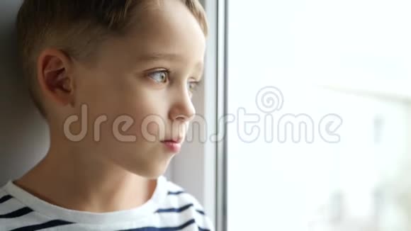 一个小孩子看着窗外悲伤悲伤和沮丧的情绪视频的预览图