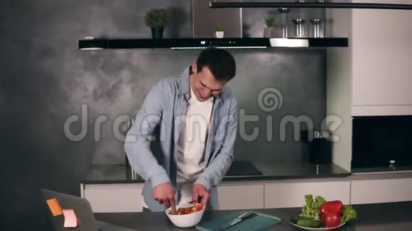 超级兴奋的年轻人拿着勺子当麦克风在厨房做饭时唱歌跳舞无忧无虑的人视频的预览图