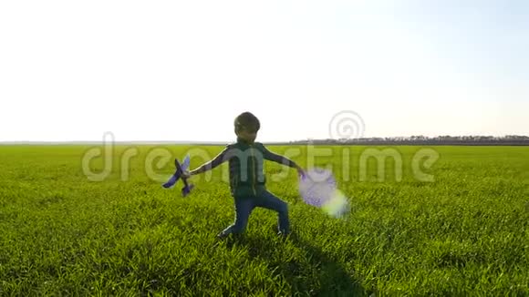一个小男孩通过在绿色的田野上发射一架玩具飞机来玩视频的预览图