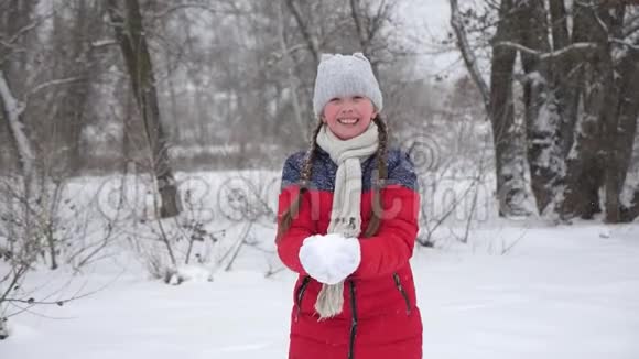 一个快乐的孩子把雪扔起来微笑圣诞节假期旅行和度假与雪的乐趣和游戏女孩视频的预览图