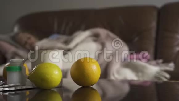 特写药丸柠檬和一杯茶咳嗽的小白种人女孩躺在背景上儿童视频的预览图