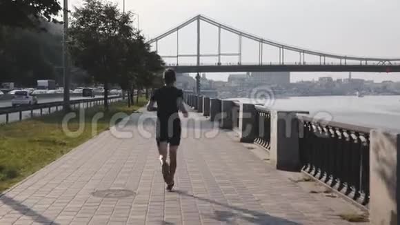年轻有魅力的运动员早晨在城市长廊上沿着河边跑步年轻强壮的人做早操年轻人视频的预览图