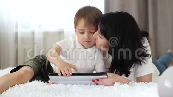 一个女人和一个小男孩用平板电脑打电话看电影上网对小工具的依赖视频的预览图