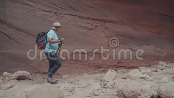 沙漠斜坡峡谷中橙色单片岩石形成的旅游徒步旅行视频的预览图