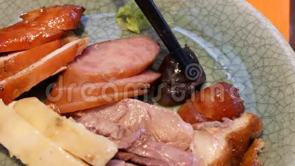 人们在盘子里吃中国香肠的动作视频的预览图