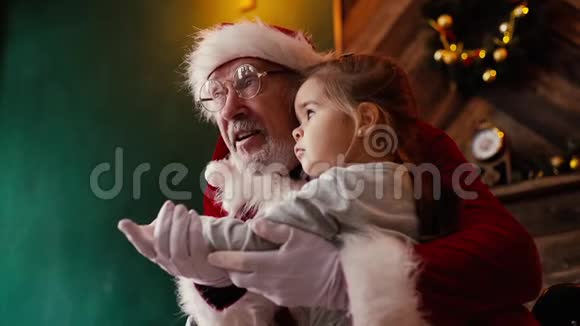 坐在圣诞老人腿上听他讲故事的小女孩视频的预览图