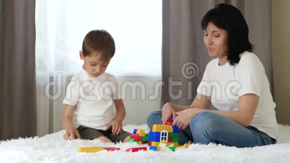 幸福家庭母子俩玩搭一栋彩色积木的房子孩子和妈妈玩笑视频的预览图