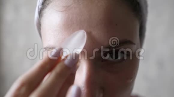 年轻女性面部皮肤的再生水在光滑完美的女性皮肤上擦冰抗皱视频的预览图