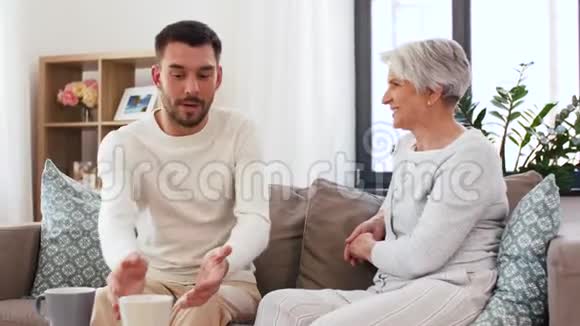成年儿子和年长母亲在家喝咖啡视频的预览图