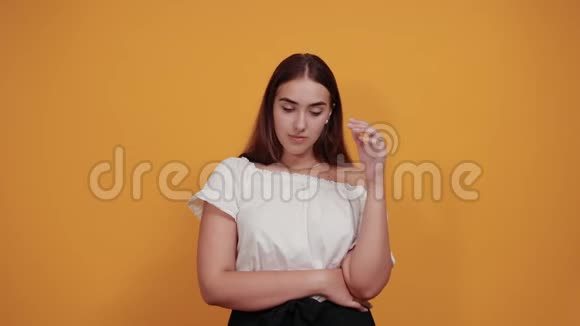 悲伤的女人手牵着头头痛头发飘散在橙色的墙上视频的预览图