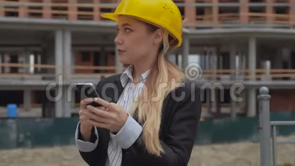 一个穿着商务服和一顶黄色安全帽的年轻女孩的肖像女建筑师的背景视频的预览图