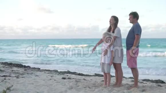 爸爸妈妈和儿子在海边散步视频的预览图