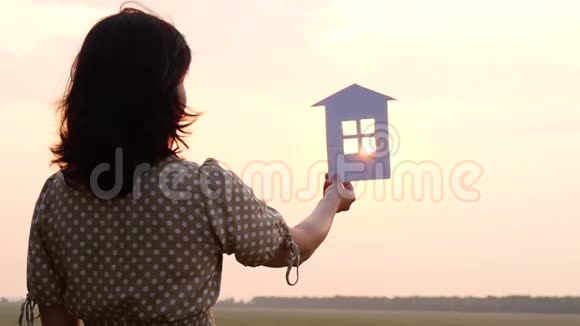 纸屋的剪影一个女人做梦拿着纸屋看着夕阳视频的预览图
