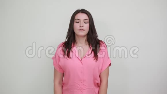 生病的年轻女子手牵着头头痛孤立在灰墙上视频的预览图