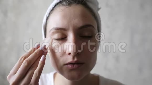 女人用冰来抚平皱纹提升眼睛下面的皮肤美容中的水合作用把冰融化在视频的预览图