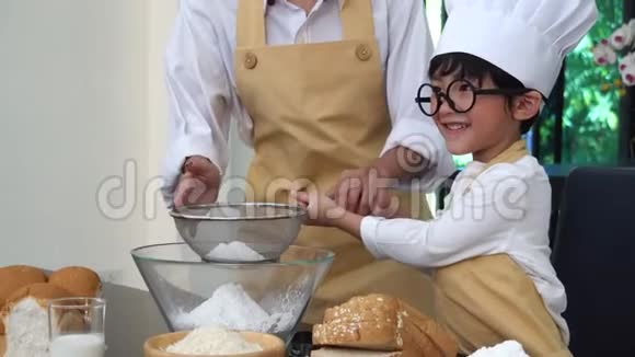 厨房里的幸福家庭妈妈教儿子做健康食品视频的预览图