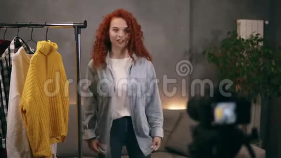 吸引人的发型师在网上博客上录制视频展示她衣柜里的时髦衣服尝试衬衫和衬衫视频的预览图