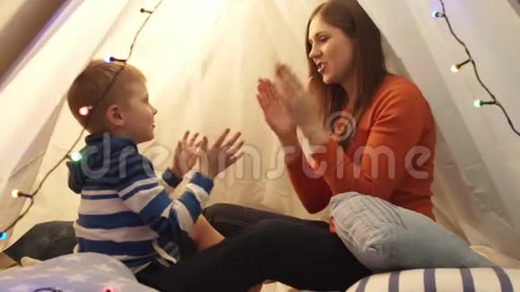 小男孩在家里的儿童帐篷里和妈妈玩快乐的白种人小孩在游戏室视频的预览图