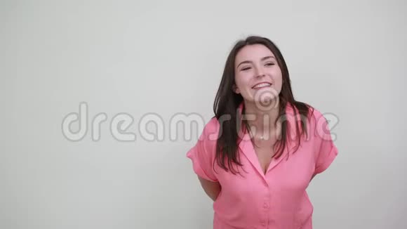 穿着粉红色衬衫的开朗女人直接用手指指着保持手在嘴上视频的预览图