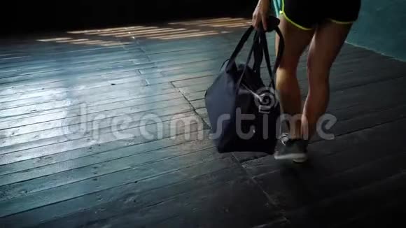 慢动作适合年轻女性的腿带着袋子进入健身房准备训练视频的预览图