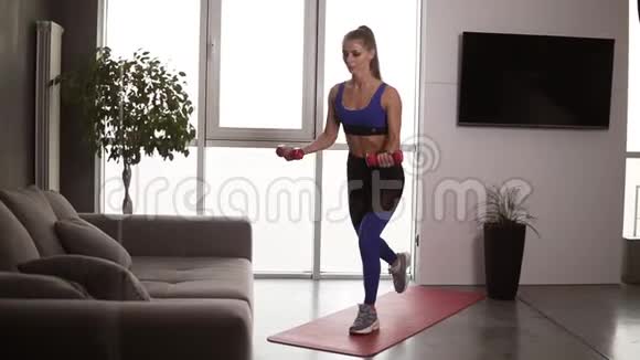 强壮的健身妇女在做午餐时举起哑铃在训练中享受适当的呼吸很漂亮的运动员视频的预览图