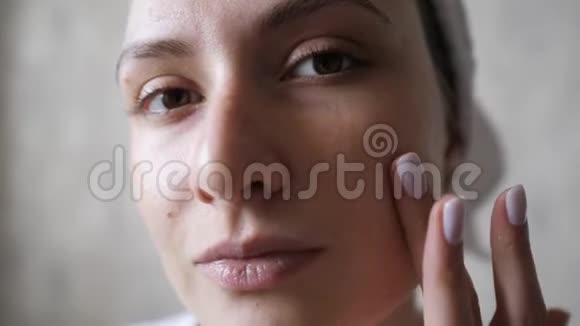 美丽的女人涂上清晰的抗衰老霜特写肖像振兴生物化妆品清洁健康女性视频的预览图