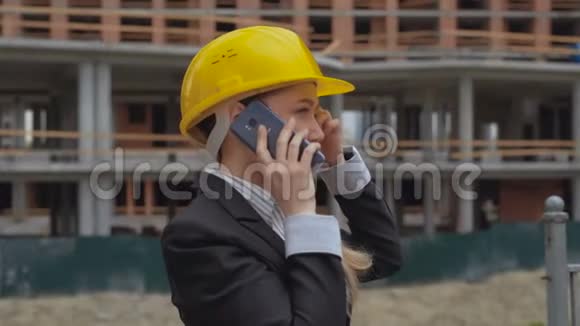 在一个建筑工地的背景下女工程师兴奋而愉快地在电话里交谈一个女人视频的预览图