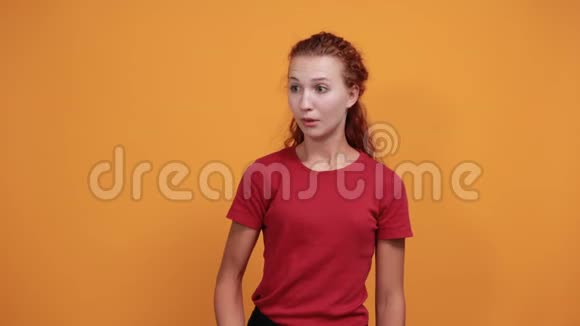 失望的年轻女士穿着红色衬衫手举在一边视频的预览图