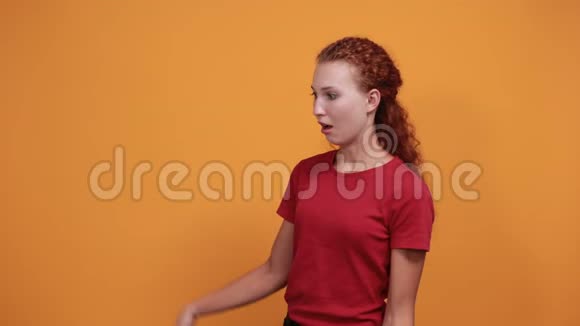 穿着红色衬衫的漂亮年轻女士双手之间露出空隙看上去很困惑视频的预览图