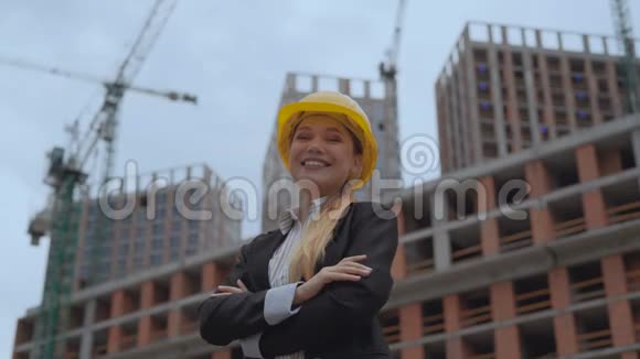 一个穿着商务服和一顶黄色安全帽的年轻女孩的肖像建筑工地的女工程师视频的预览图