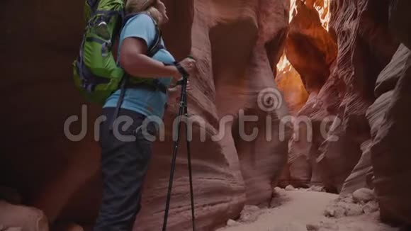 徒步旅行者在一个有着橙色岩石的深绿色峡谷中环顾四周视频的预览图