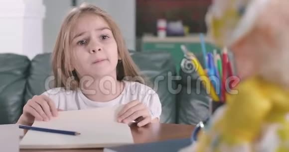 可爱的白种人女孩在镜头后面和某人说话并露出她的舌头的肖像不满意的儿童视频的预览图