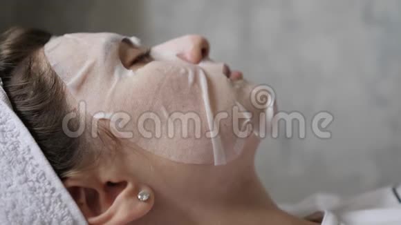 在灰色墙壁背景上戴面具的女性轮廓天然化妆品制成的皮肤保湿剂视频的预览图