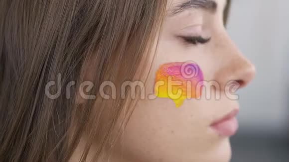 一个年轻漂亮女人的详细肖像社交媒体的多色图标画在女孩脸上身体艺术视频的预览图