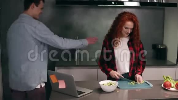 有趣的一对夫妇在灰色的厨房一起做饭年轻活跃的家庭玩得开心笑起来感觉无忧无虑视频的预览图