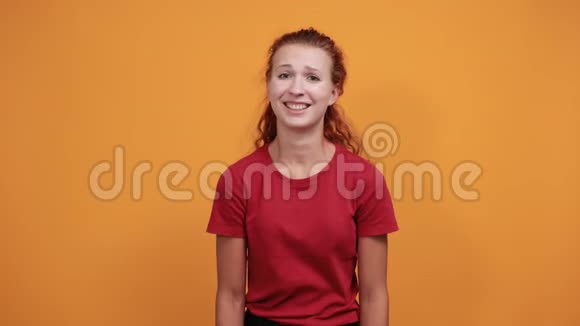 穿着红衬衫的漂亮年轻女士用手遮住眼睛微笑着笑着视频的预览图