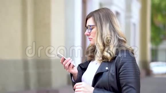一个戴眼镜的漂亮女孩在智能手机上讲话视频的预览图