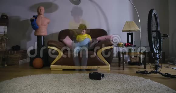 双曝光时间推移可爱的白种人男孩与卷发花时间在家里儿童坐在沙发上地板上视频的预览图