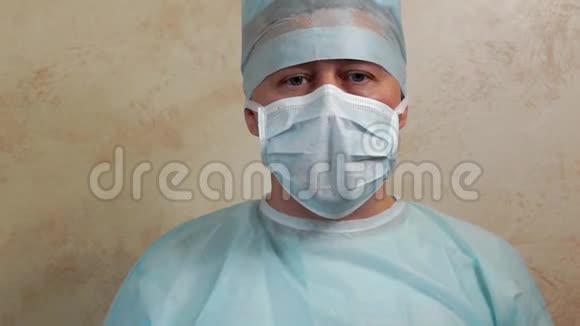 穿着无菌长袍口罩帽子和手套说话的医生视频的预览图