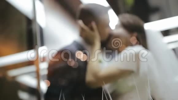 新郎和新娘在电梯里接吻拥抱是新婚夫妇一个女孩拉着一个男人的夹克给自己婚礼爱情视频的预览图